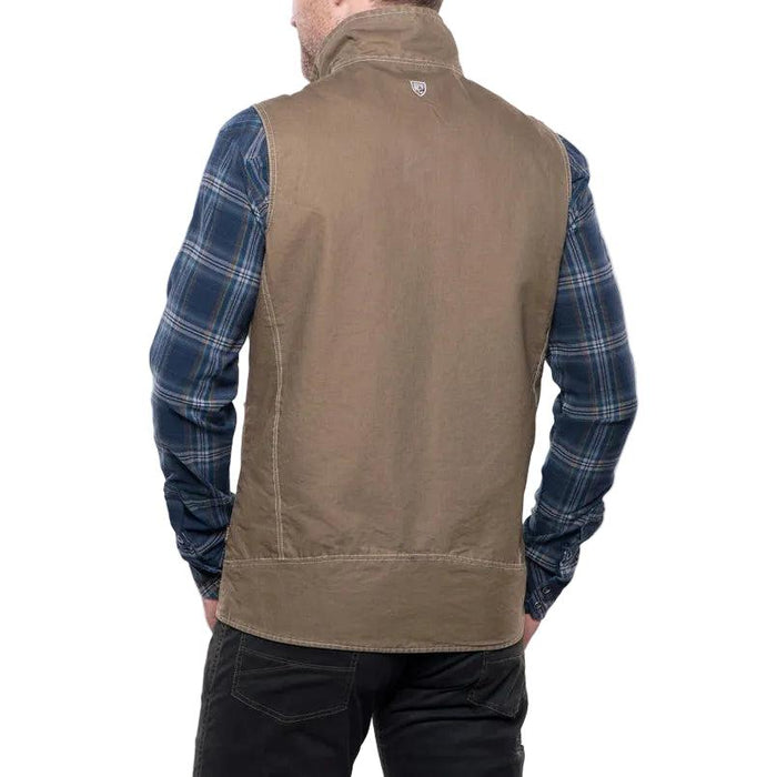Back view of a brown Kuhl cotton canvas vest worn over a blue plaid flannel shirt.