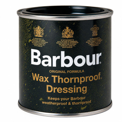 Black metal tin of Barbour Wax Thornproof Dressing with gold royal warrant logos and white branding text.