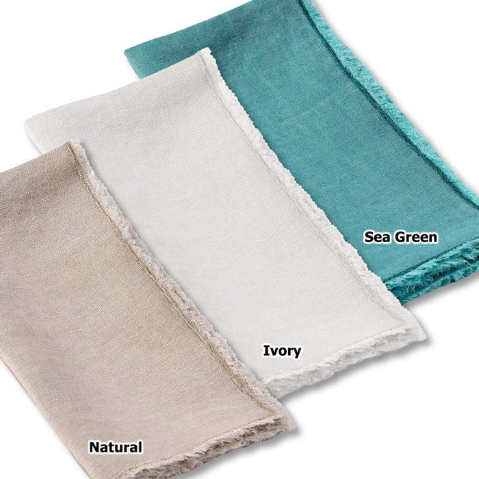 Set of three stone-washed linen-cotton napkins in natural, ivory, and sea green with handmade fringed edges.