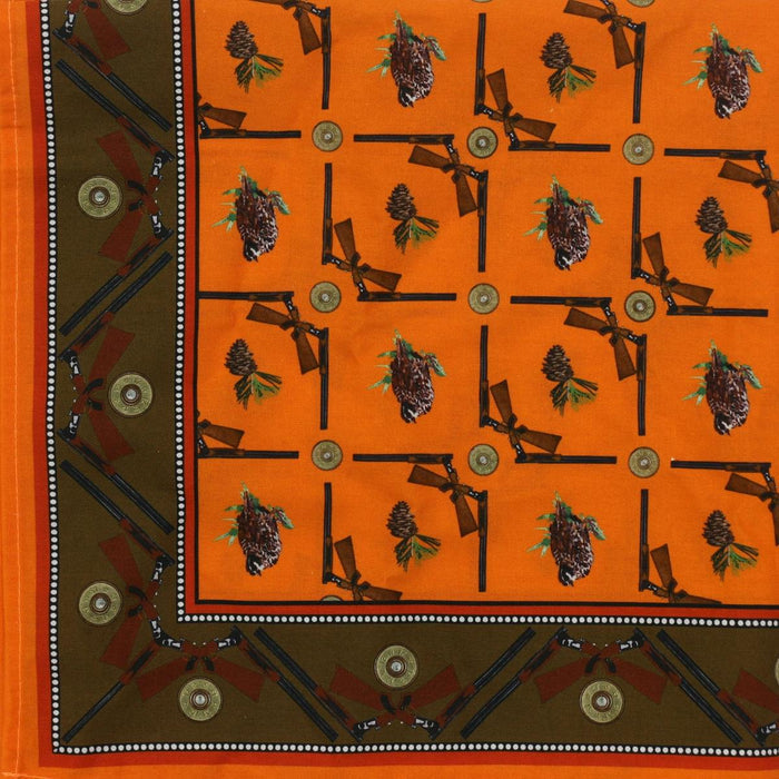Orange 100% cotton dinner napkin featuring a hunting-themed print of crossed guns, quail, and pinecones with a brown border.