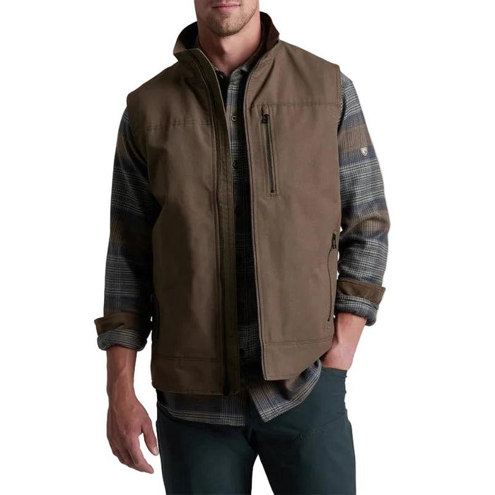 Brown Kuhl Burr canvas vest with a zip-up chest pocket and fleece lining worn over a plaid flannel shirt.