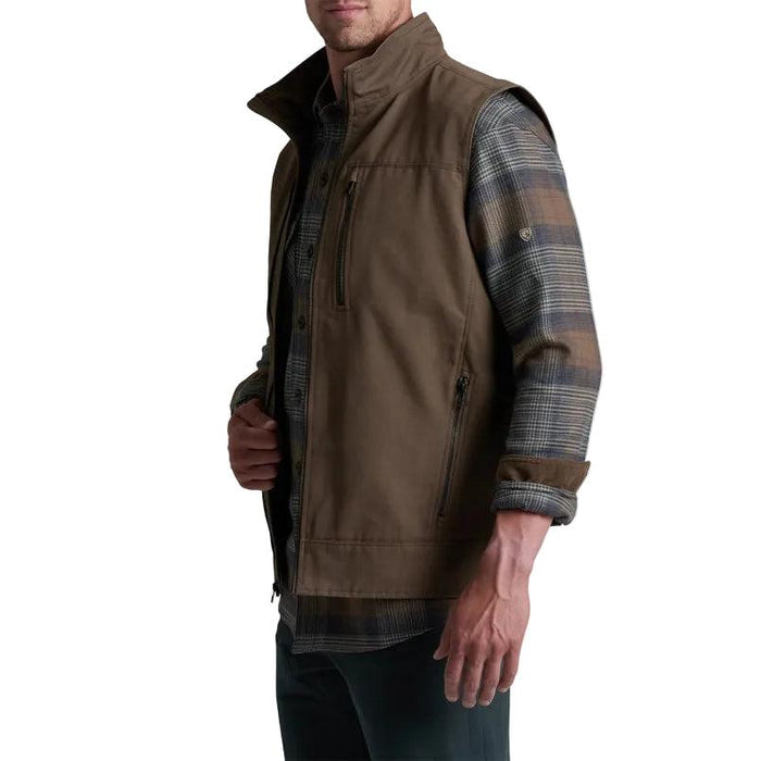 Men's brown cotton canvas Burr vest with zip chest and hand pockets layered over a plaid flannel shirt.