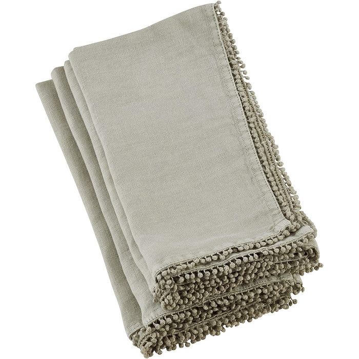 Folded beige linen-cotton blend napkin featuring a decorative pompom trim edge for a textured, elegant table setting.