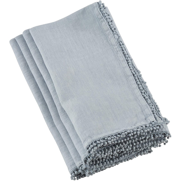 Folded light blue linen-cotton blend napkin featuring a decorative pompom trim edge for a playful, elegant dining accent.