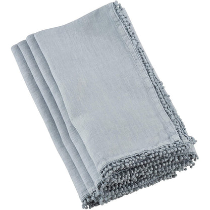 Folded light blue linen-cotton blend napkin featuring a decorative pompom trim edge for a playful, elegant dining accent.
