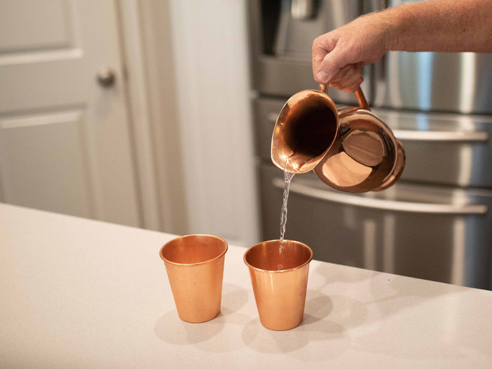 Copper Pitcher pouring into 2 copper tumblers