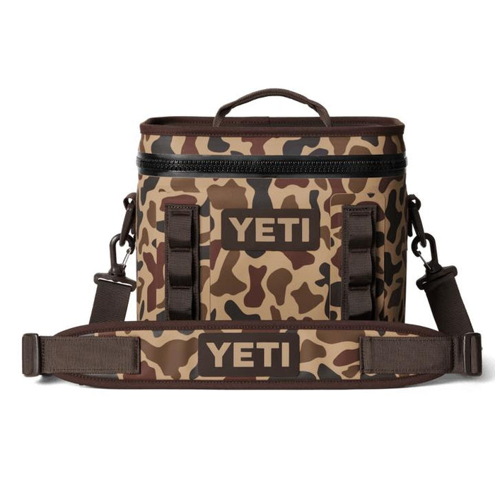 YETI Hopper Flip 8 soft cooler in brown camo print with a durable waterproof shell, top handle, and padded shoulder strap.