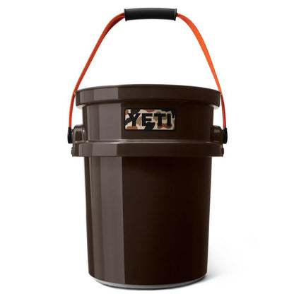 Brown YETI LoadOut 5-gallon bucket with an orange handle and camo logo patch on a white background.
